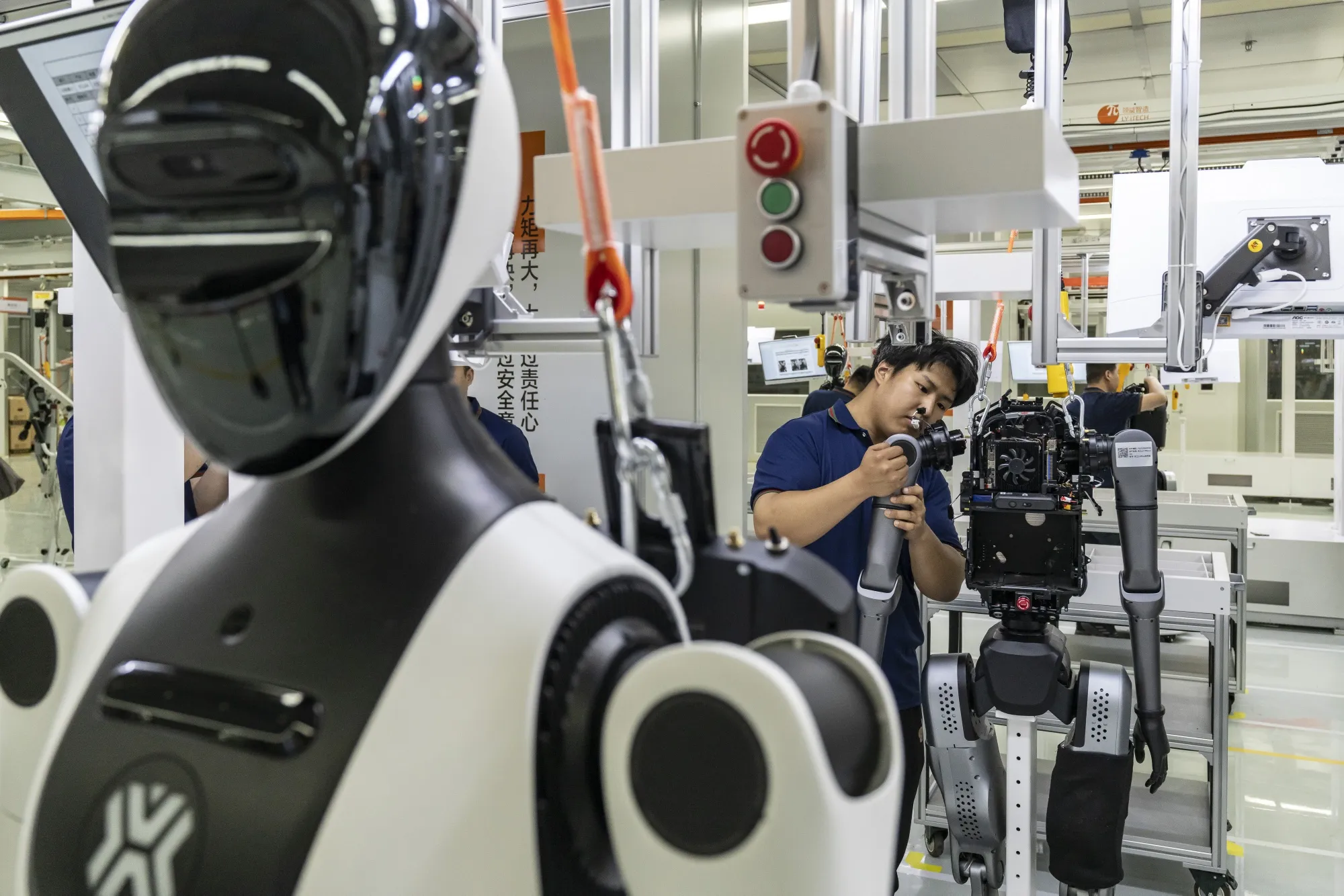 Des techniciens assemblent des robots humanoïdes dans une usine en Chine