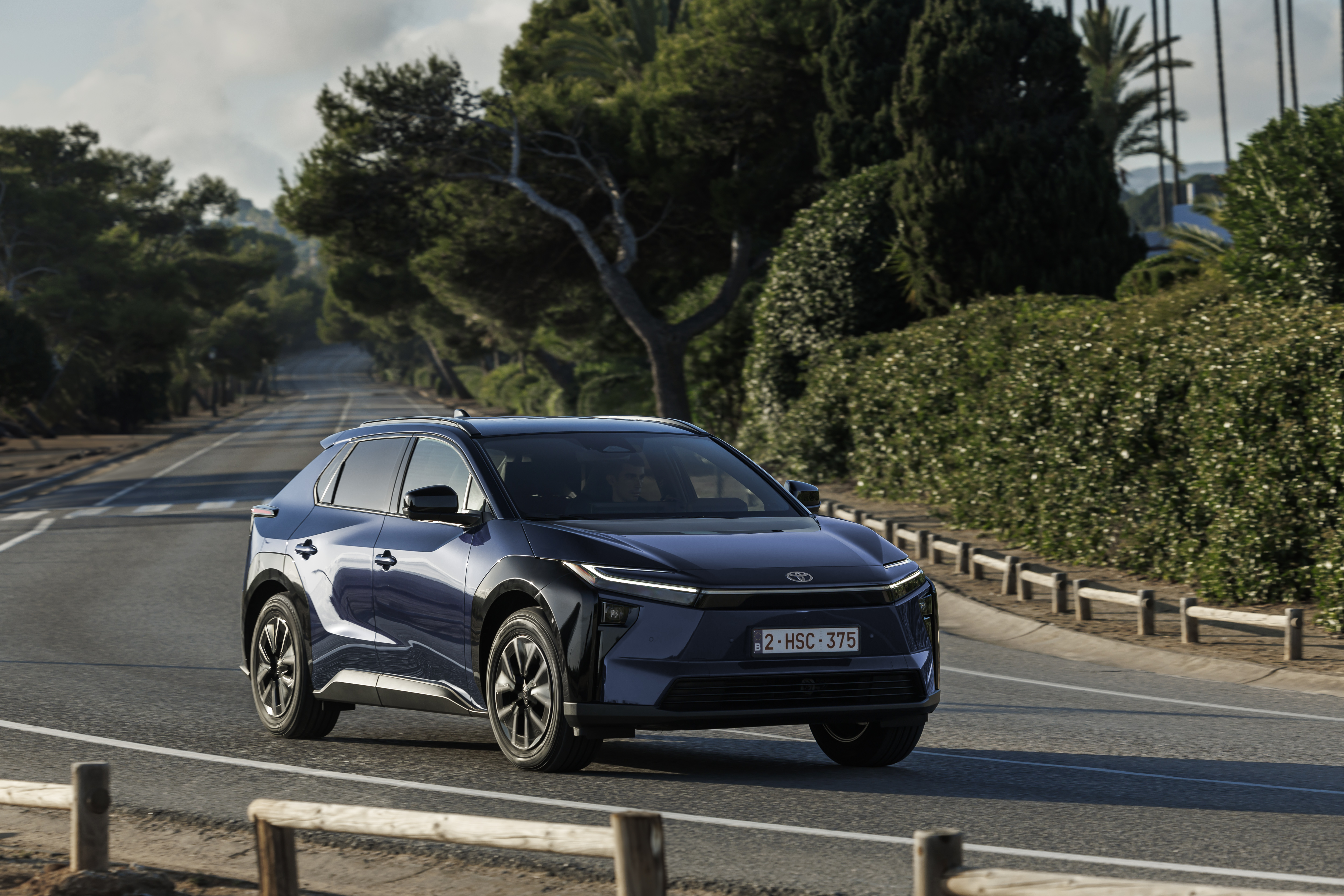 2026 Toyota bZ4X в движении, вид спереди на глубоком синем металлике