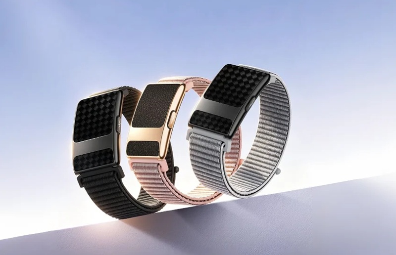 Disponible en negro, gris y rosa, con correas de silicona o tela tejida.